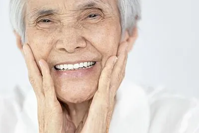 woman smiling with implant-supported dentures from Gateway Oaks Dental