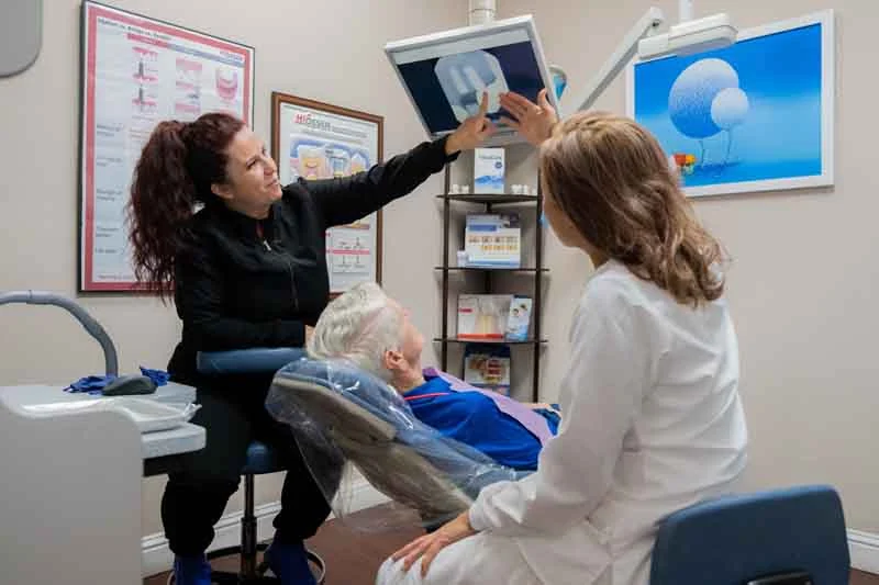 Emergency dentistry patient going over his 3d scans with Dr. Truong and her dental assistant