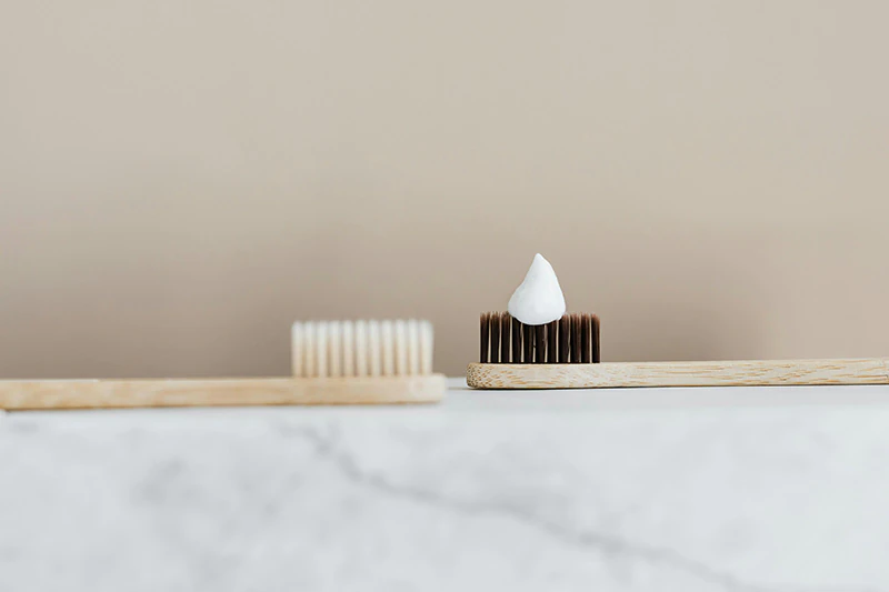Bamboo toothbrush with toothpaste on marble surface